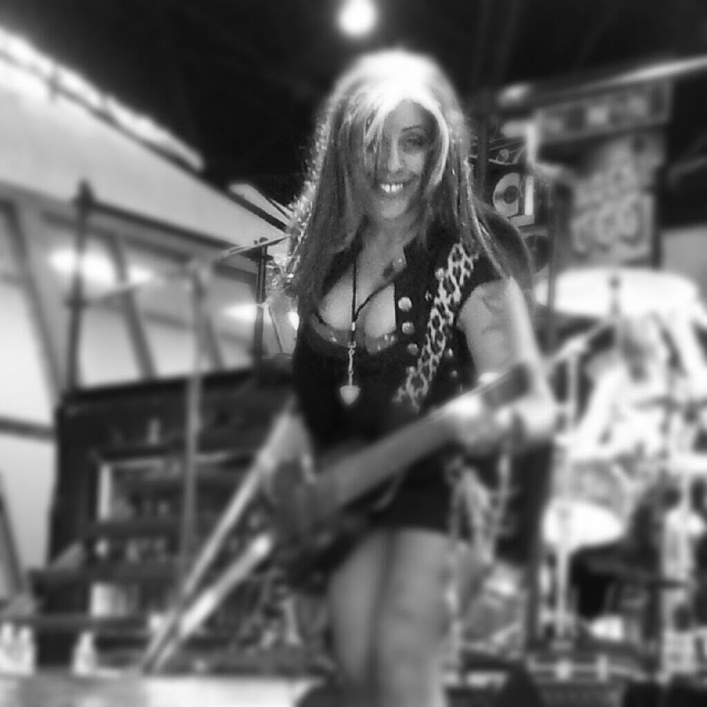 Merry Adin playing bass in a black-and-white live moment