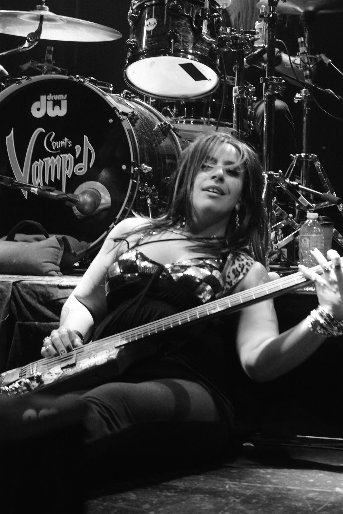 Merry Adin seated at the front of the stage with her bass